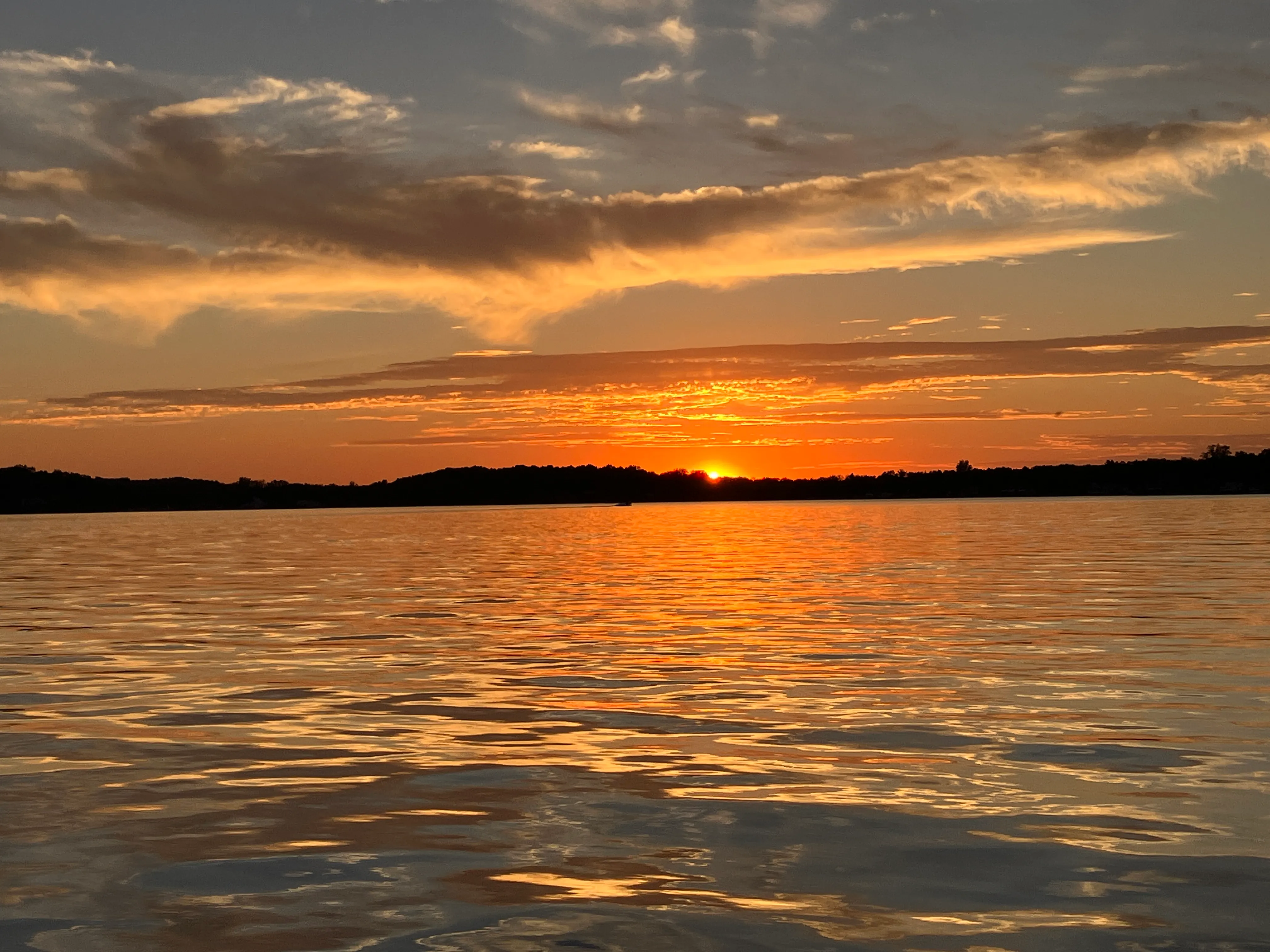 Sunset over Klinger Lake, with orange light reflecting across calm water.